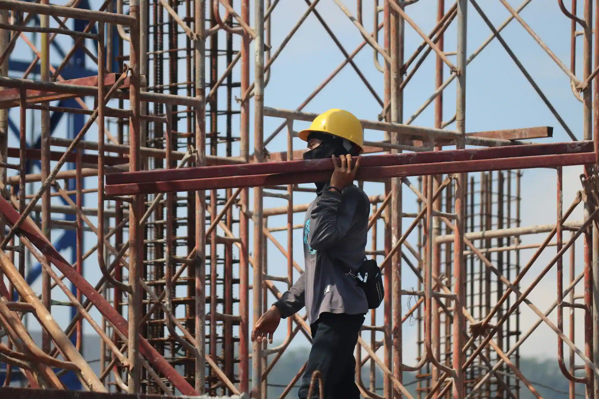 Las Vegas Scaffolding Rental worker carrying scaffold beams on construction site